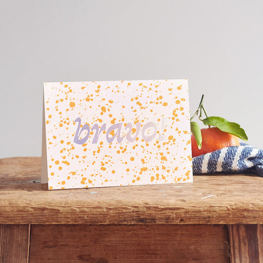 Greeting card with 'bravo' on a wooden surface