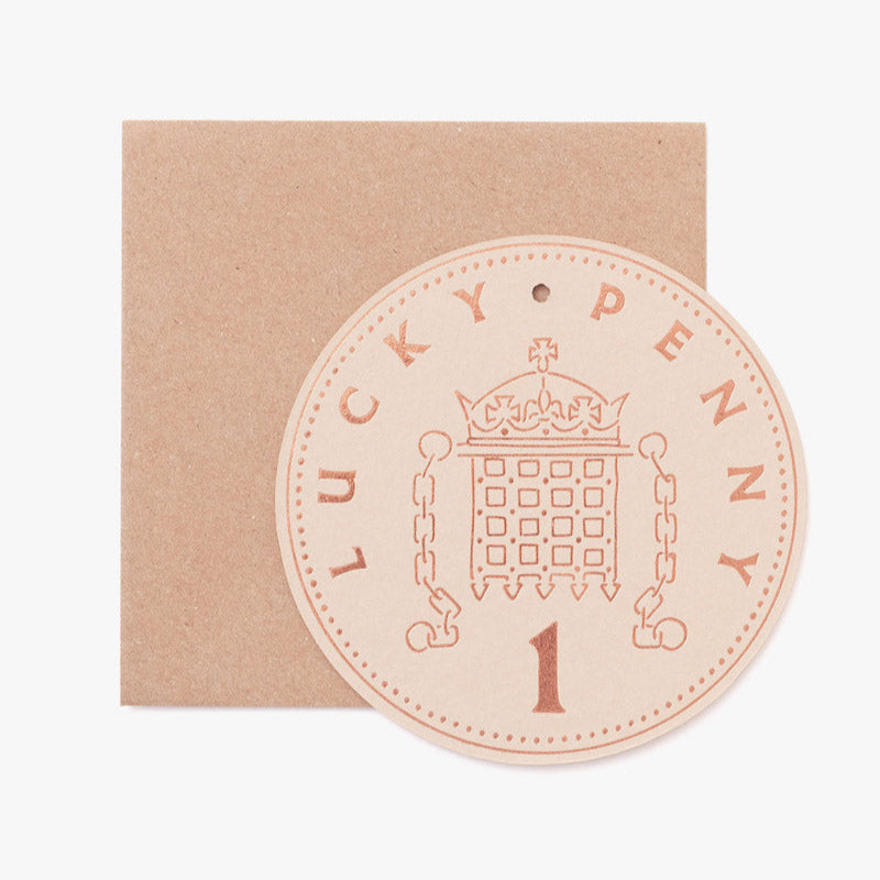 Round 'Lucky Penny' token with a design on a brown card