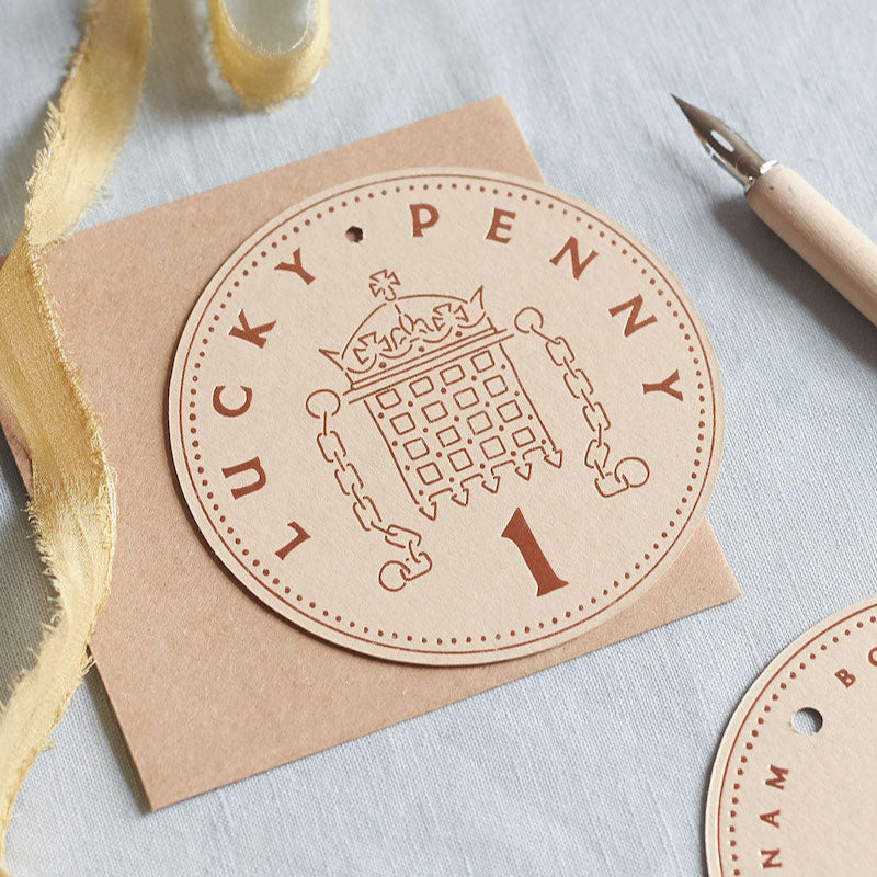 Round brown label with 'Lucky Penny' design on a light blue background